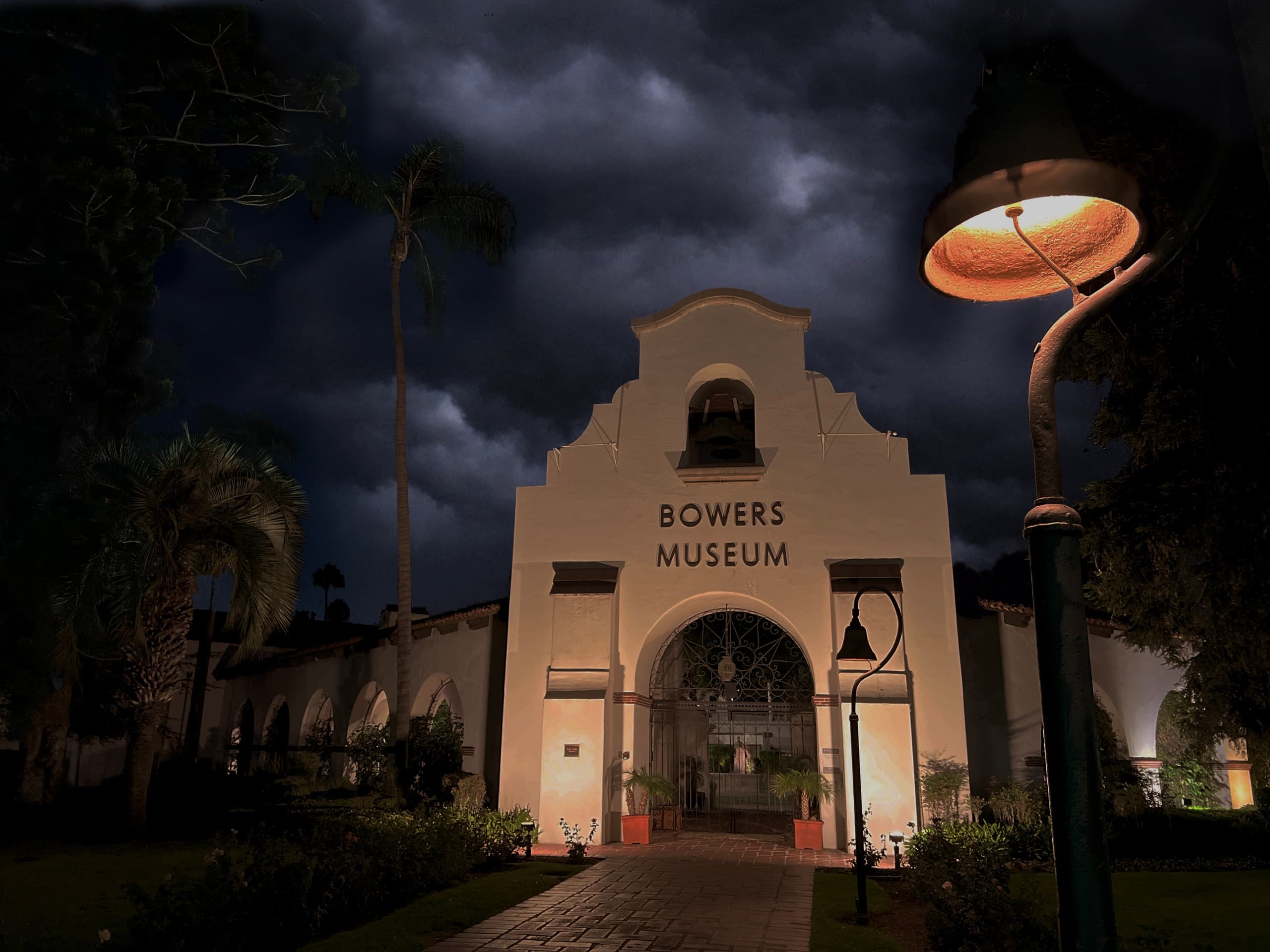 Historic museum entrance lit at night with dramatic lamp foreground