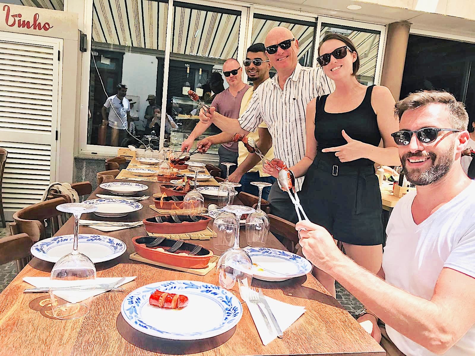 Friends enjoying seaside outdoor tapas lunch on sunny terrace