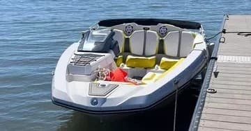 Open bow speedboat tied to dock for lakeside tubing and cruising
