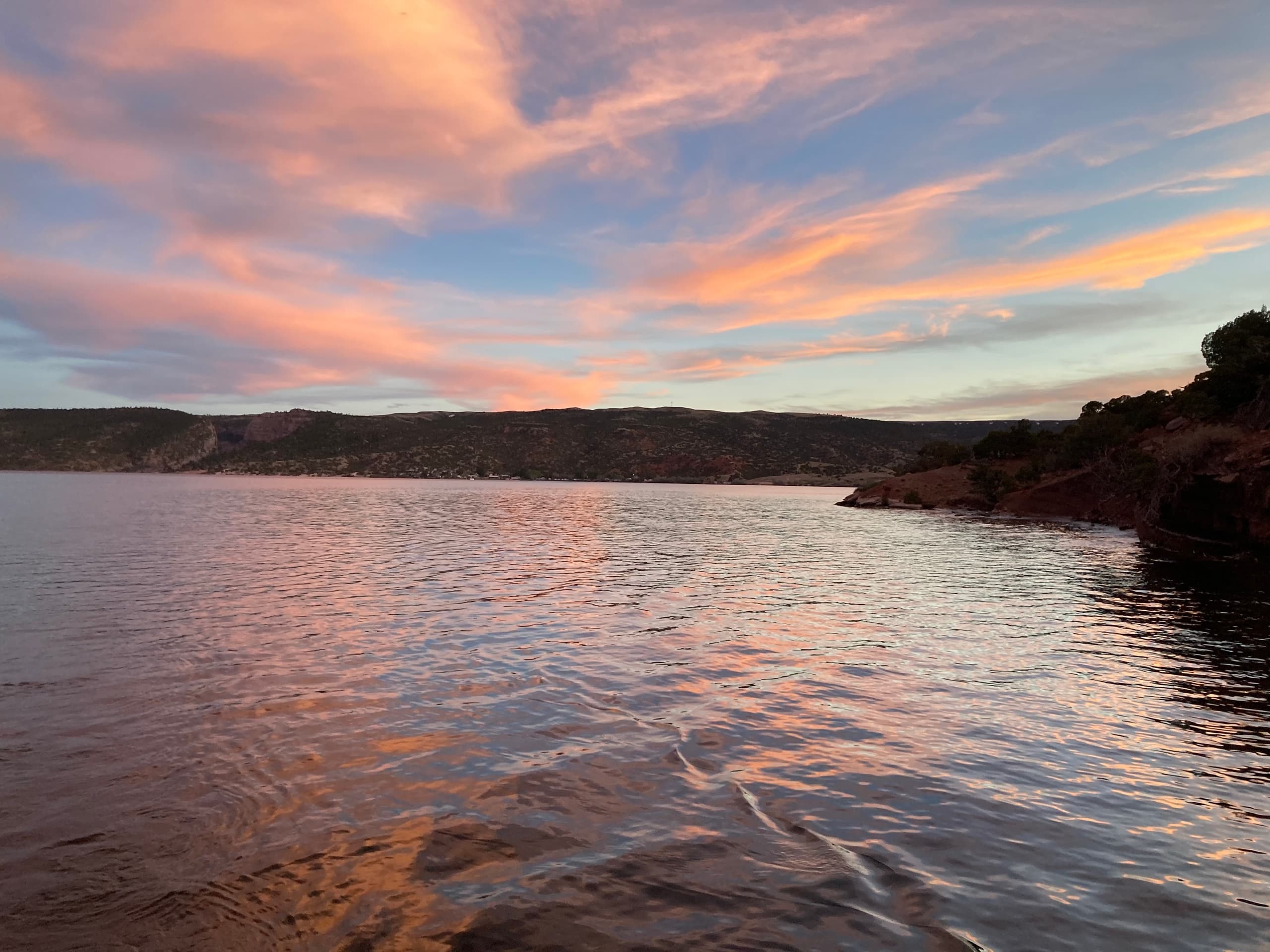 Sunset over calm lake with colorful sky and reflective water