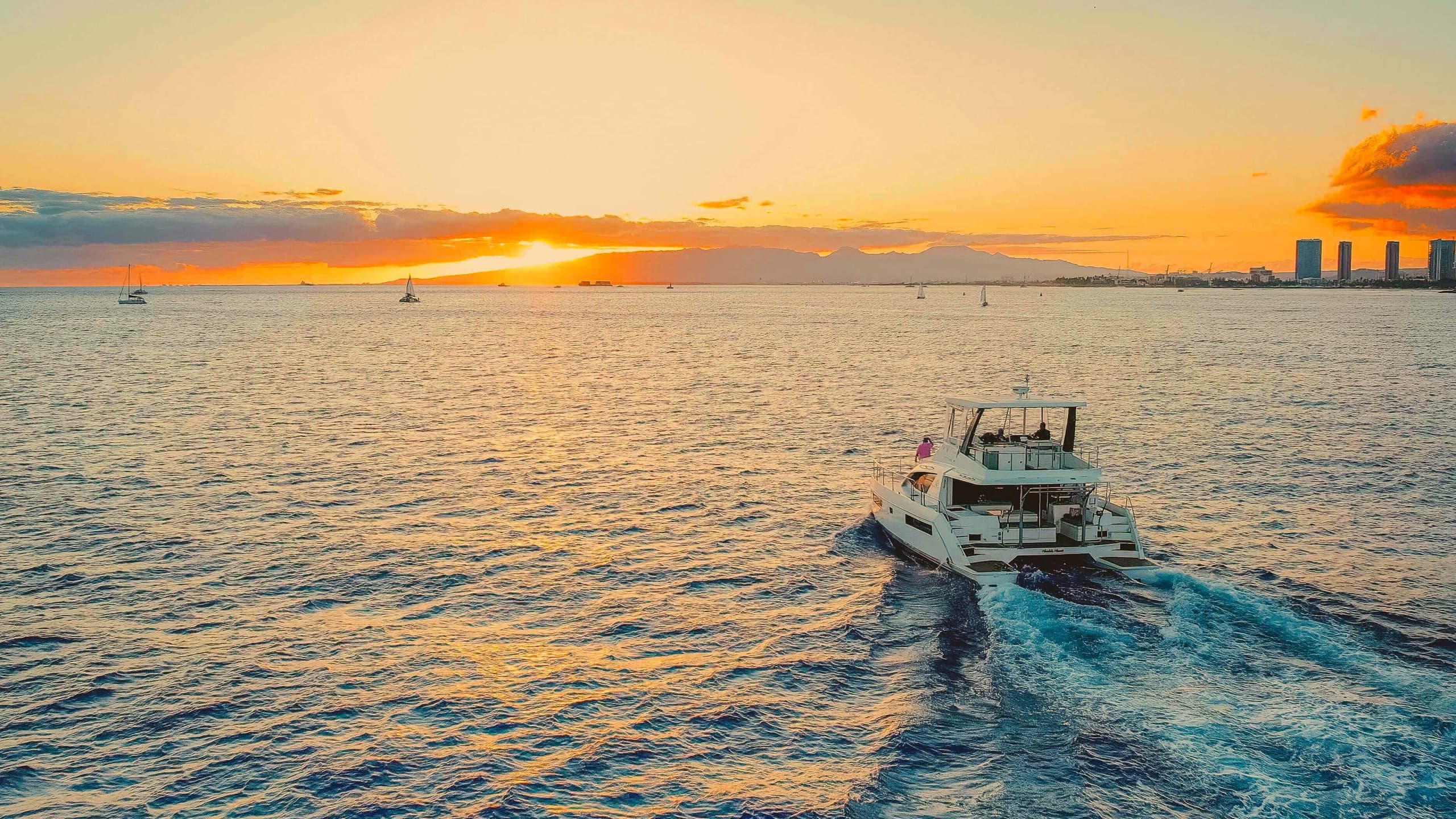 Motorboat cutting through golden sunset waters toward city
