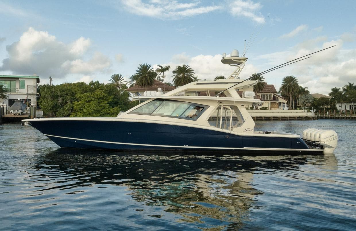 Luxury motor yacht cruising calm coastal waters near palm-fringed shoreline