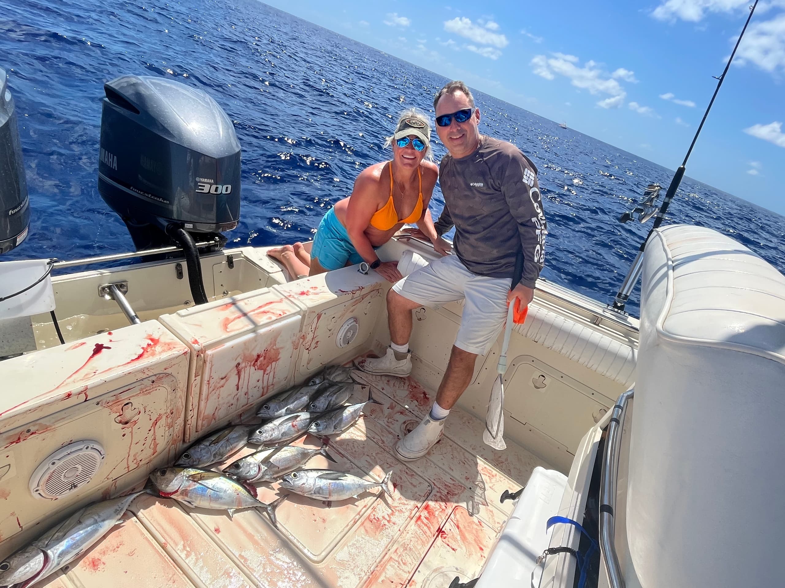 Couple with mixed catch on boat deck during deep sea fishing