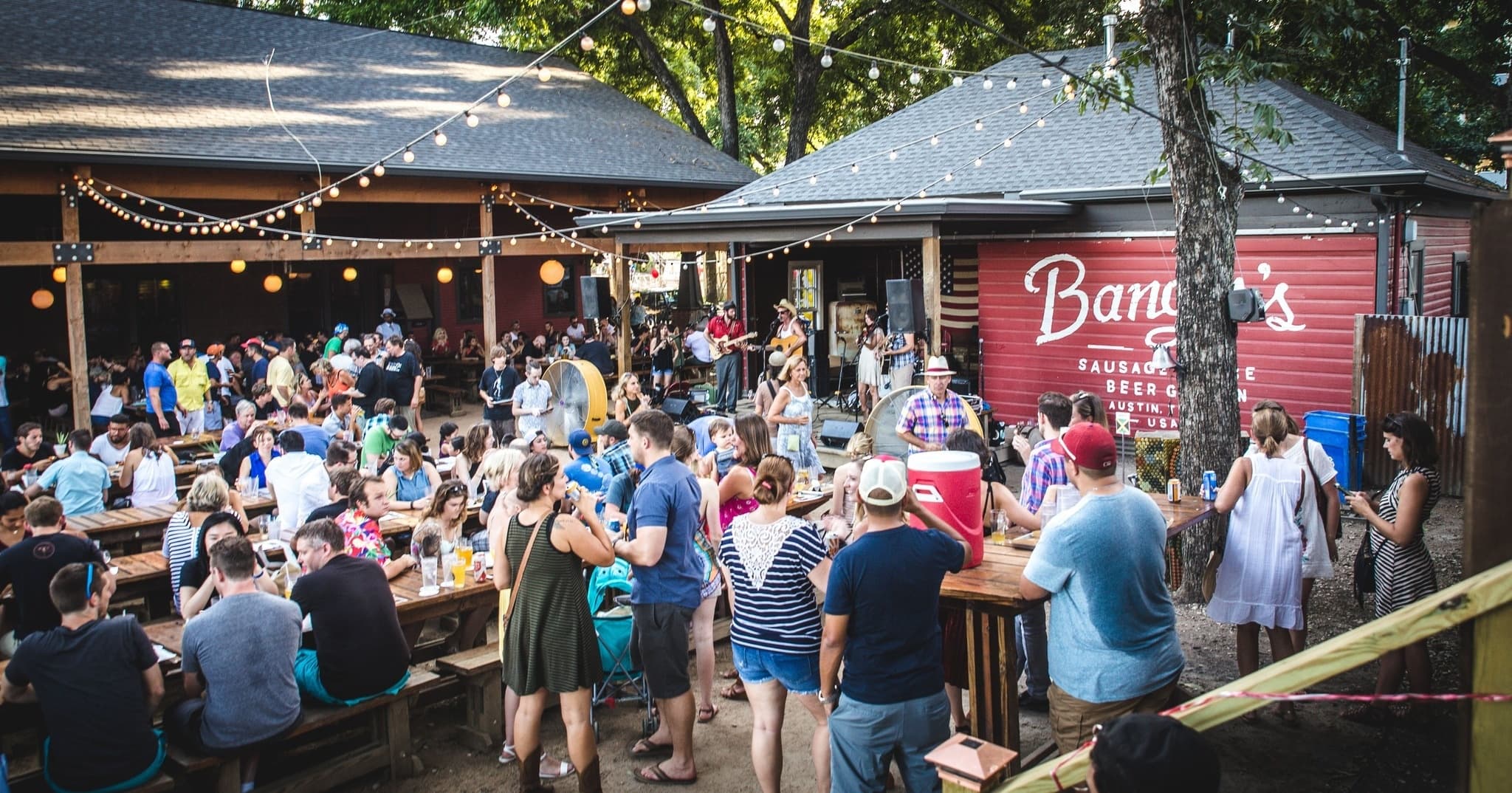 Lively outdoor patio crowd enjoying drinks at neighborhood bar