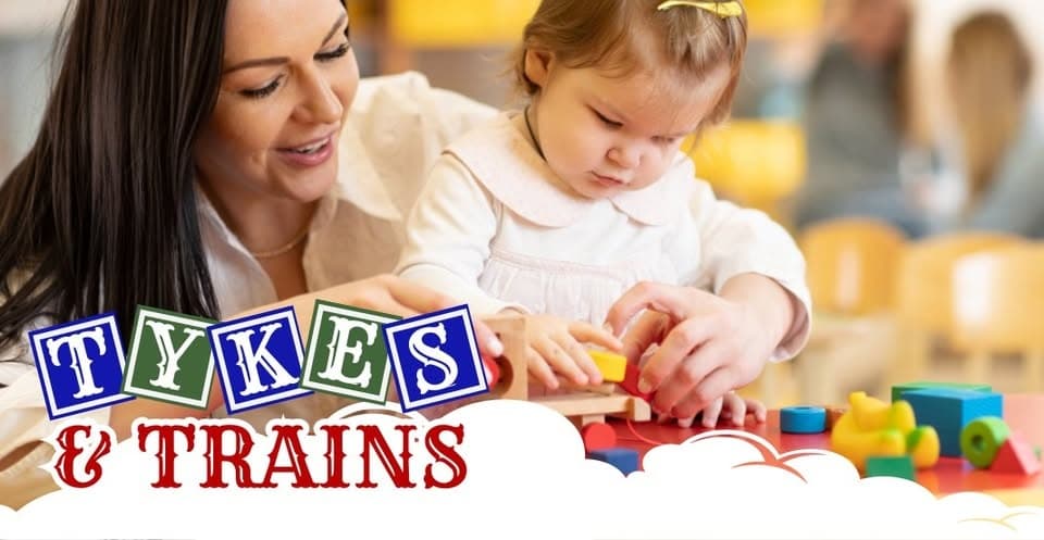 Child playing with toy trains at Tykes & Trains indoor play area