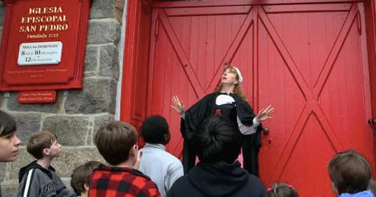 Guide storytelling at red church door during Salem tour