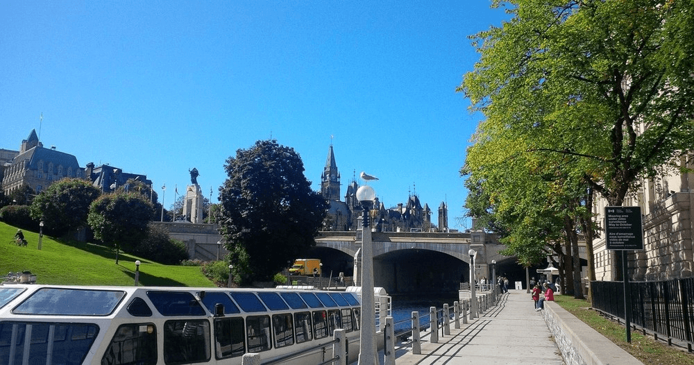 Scenic Rideau Canal walkway in Ottawa with tour boats