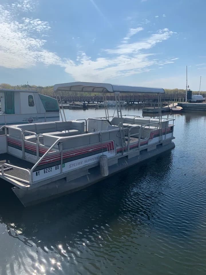 Pontoon boat docked at marina for scenic bay cruising and fishing