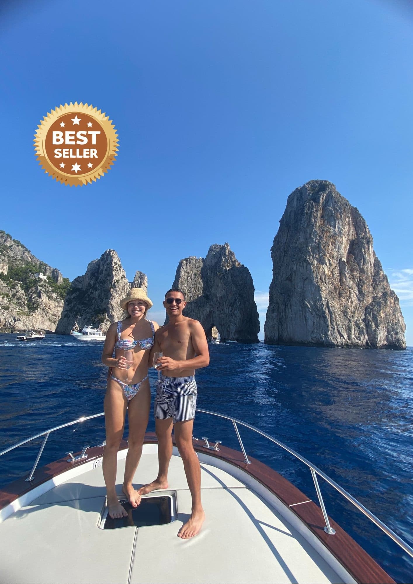 Couple posing on bow with towering sea stacks, coastal cruise
