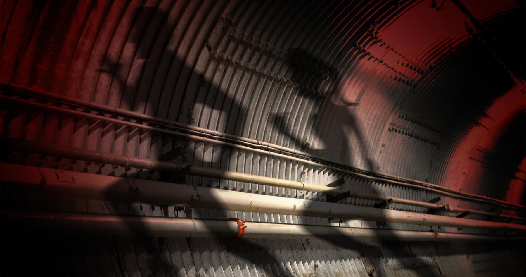 Silhouetted figures walking through atmospheric underground tunnel interior