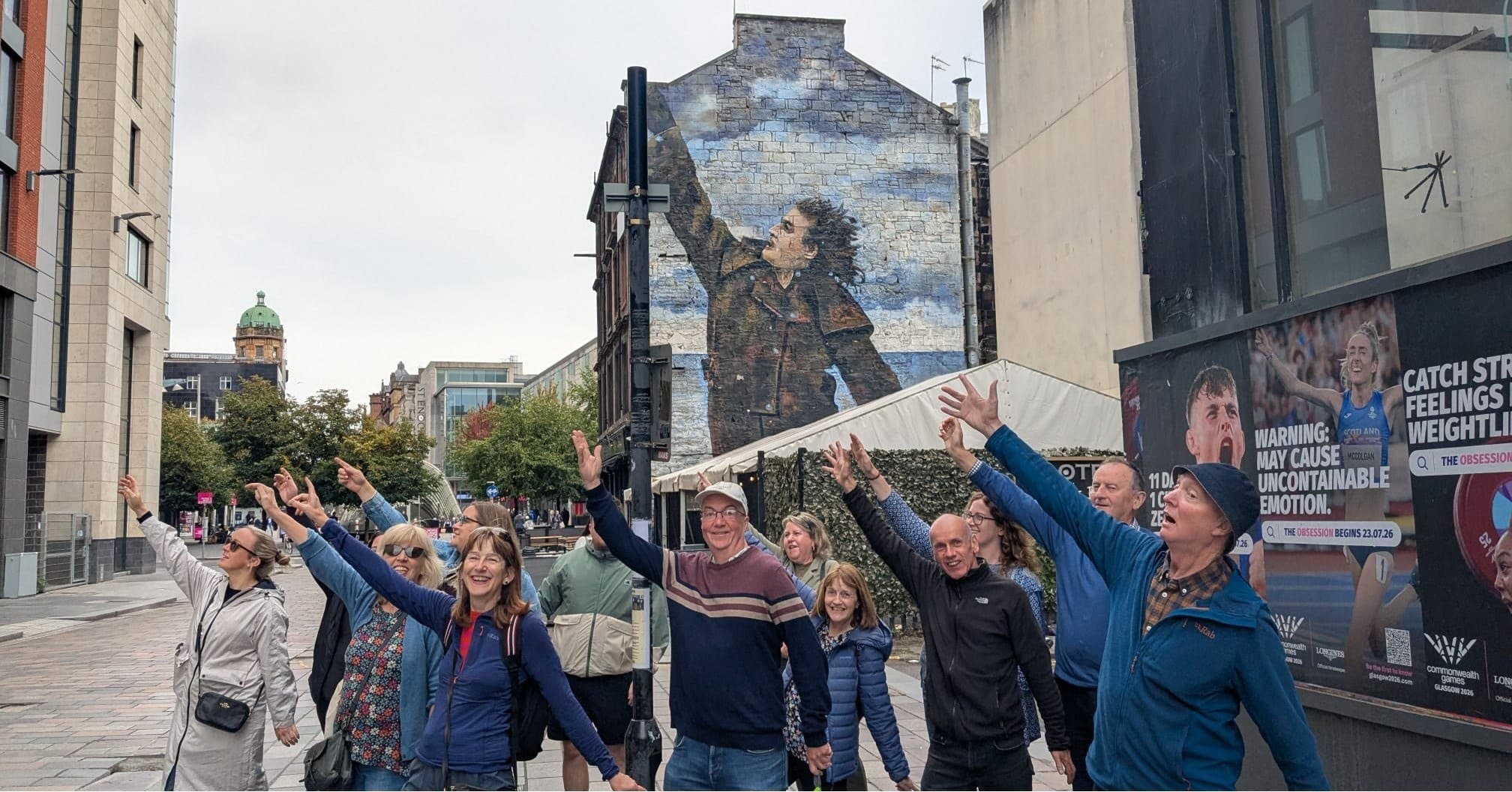 Guided street bike tour group pointing at large city mural