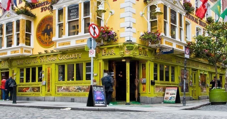 Colorful pub exterior on cobblestone Dublin street, outdoor crawl