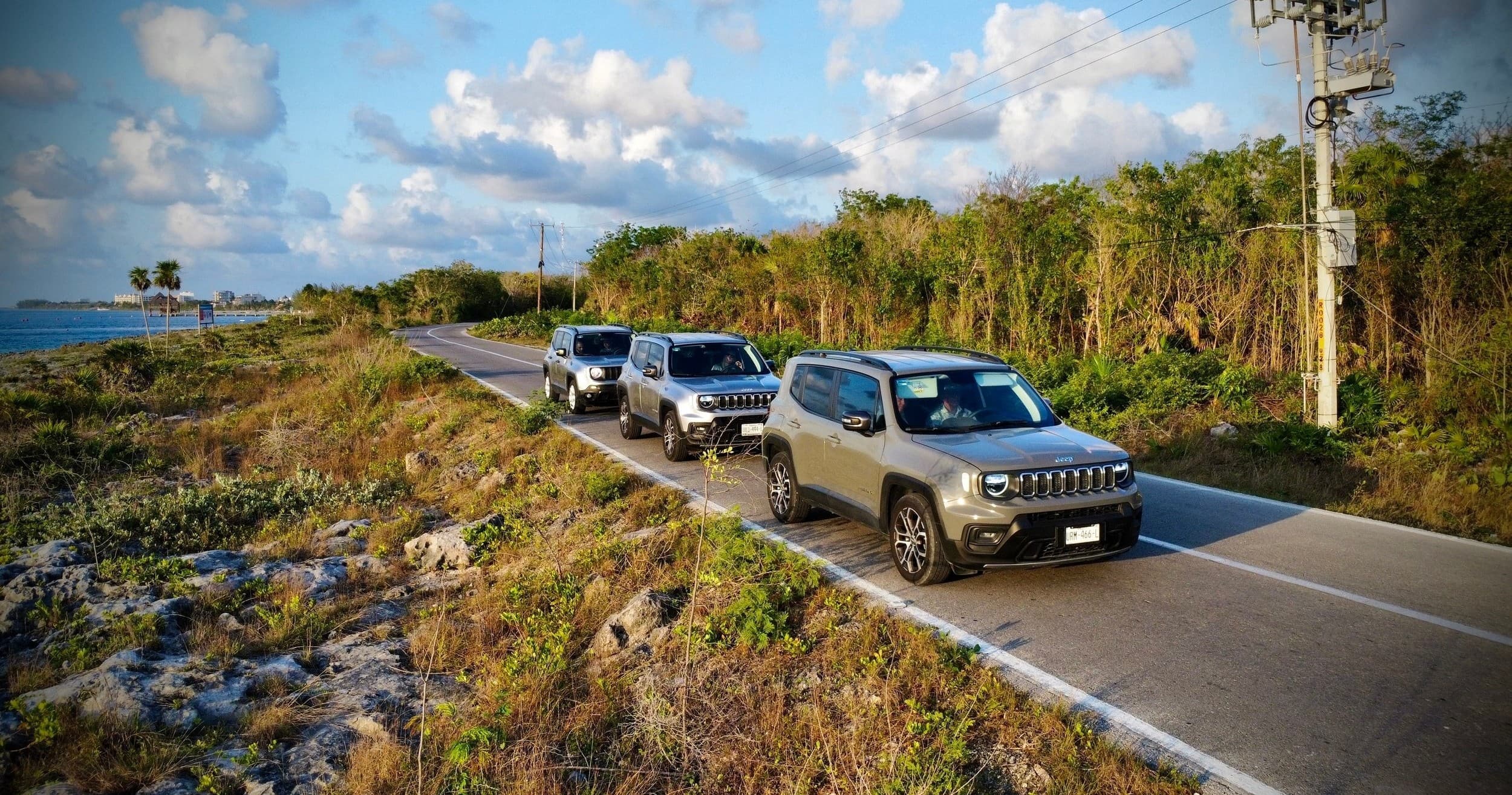 Scenic convoy of SUVs on Cozumel coastal road through jungle