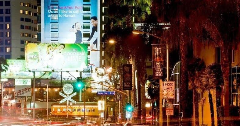 Nighttime Sunset Strip street with neon signs and palm trees