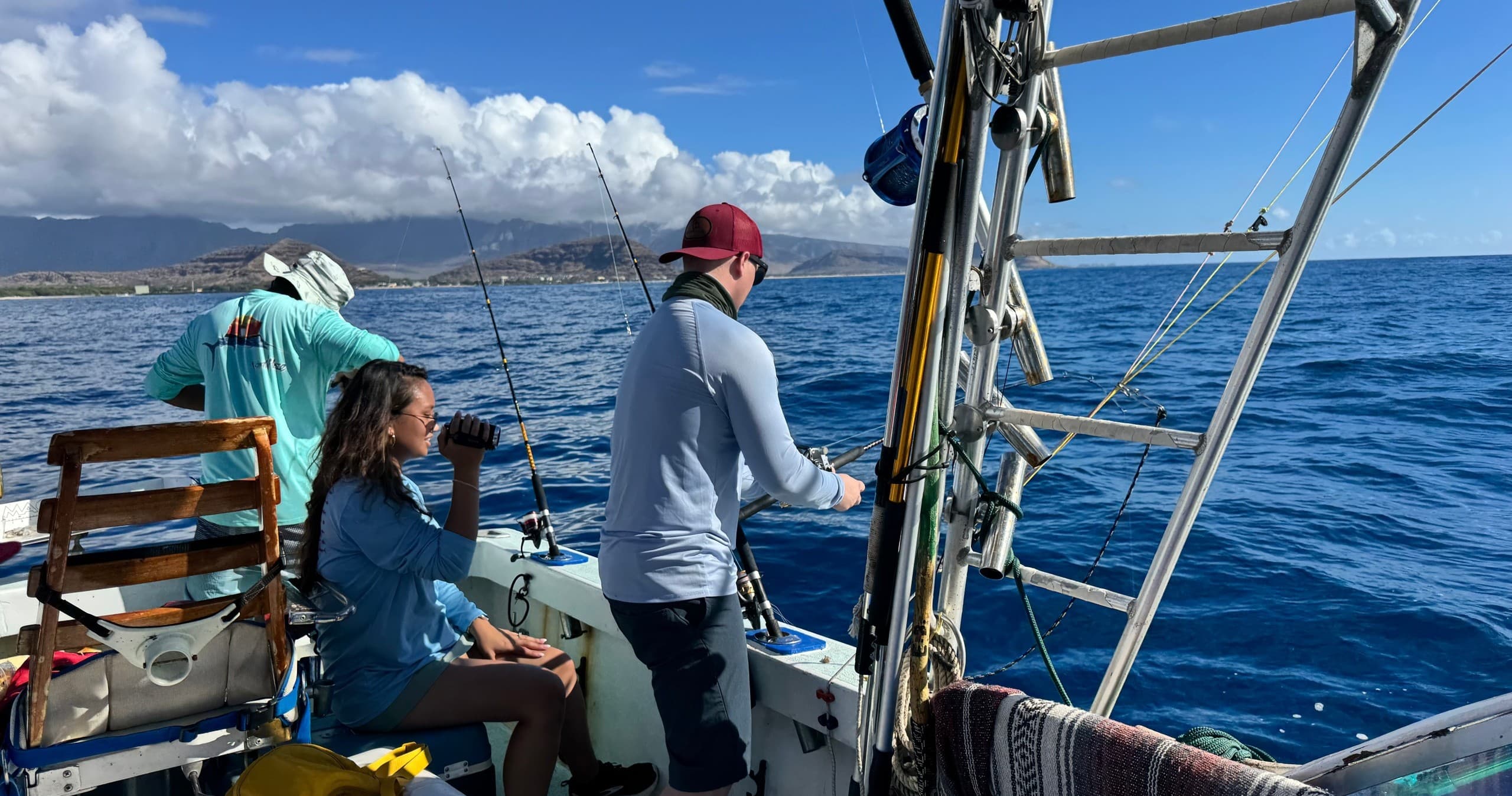 Group deep-sea fishing from boat with ocean vistas, Hawaii