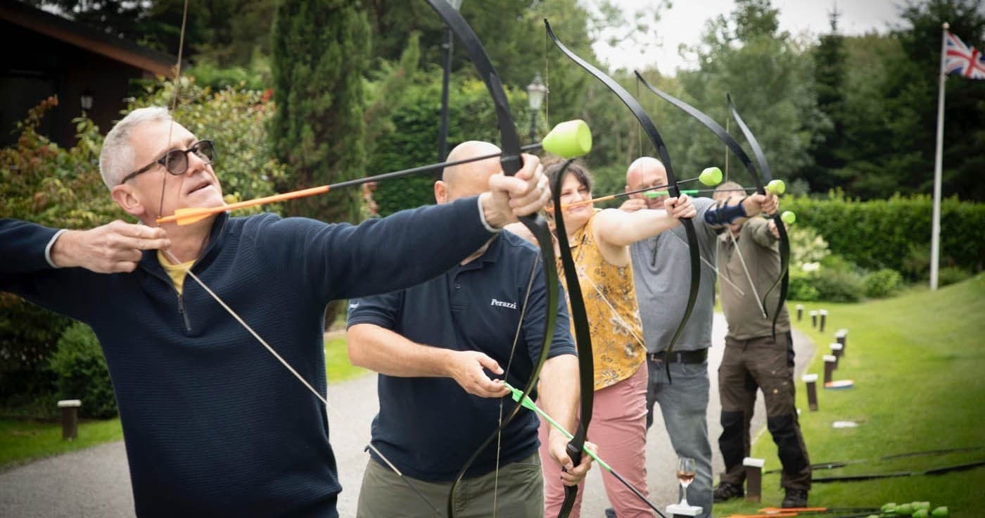 Line of archers practicing target archery in open parkland