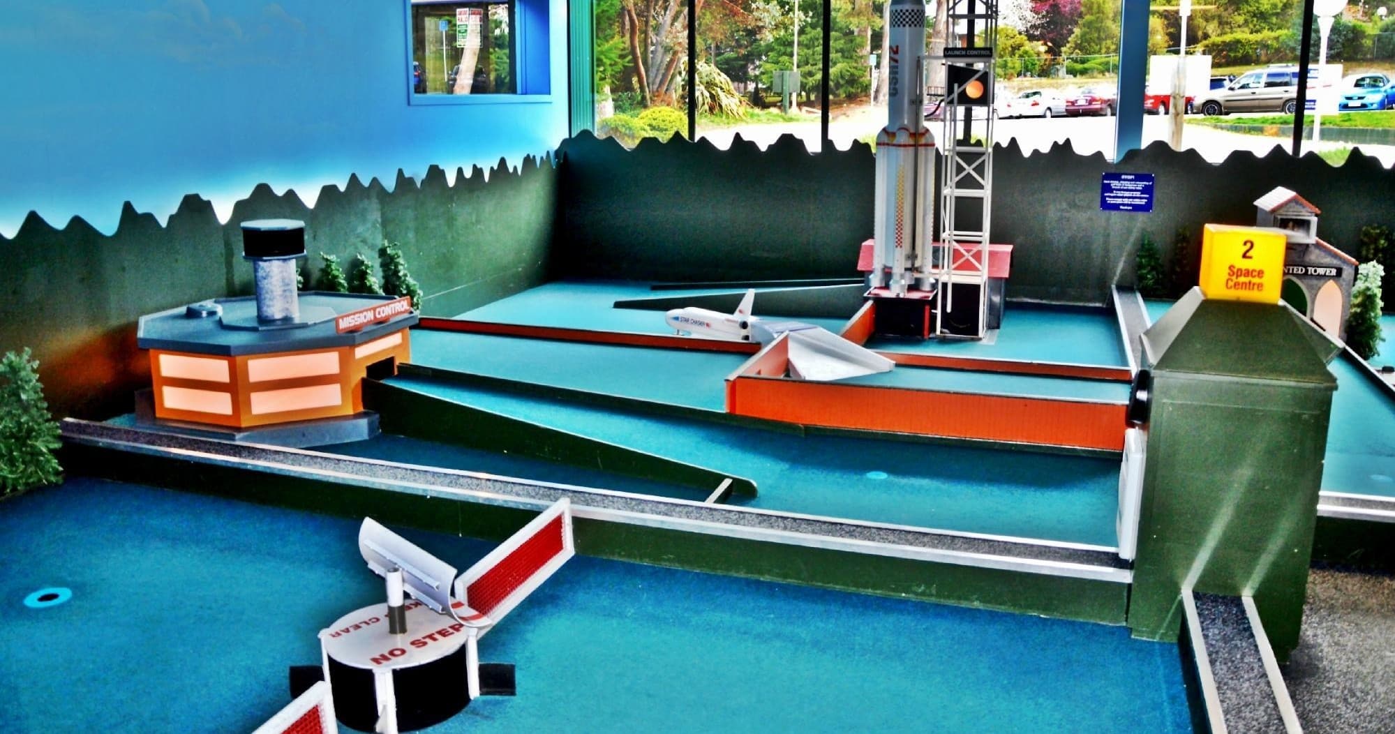 Colorful miniature golf obstacle with nautical-themed indoor setting