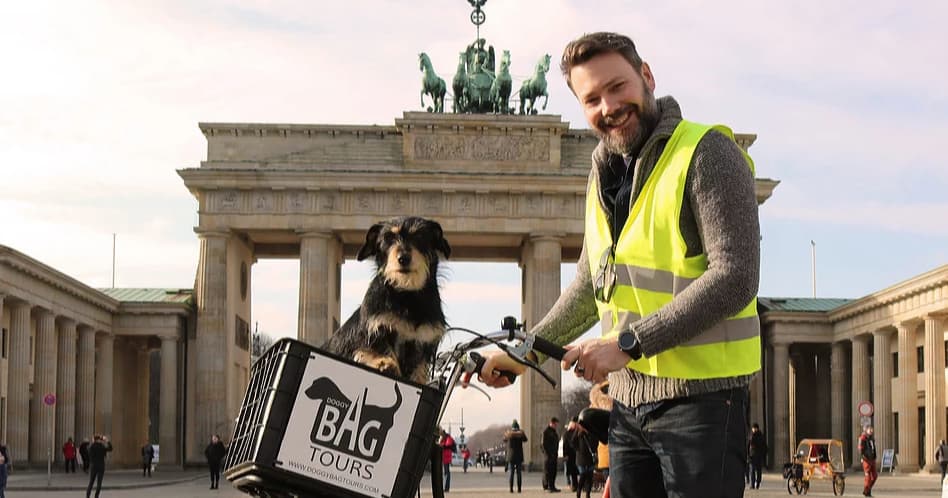 Tour guide and dog with bike at Brandenburg Gate, Berlin