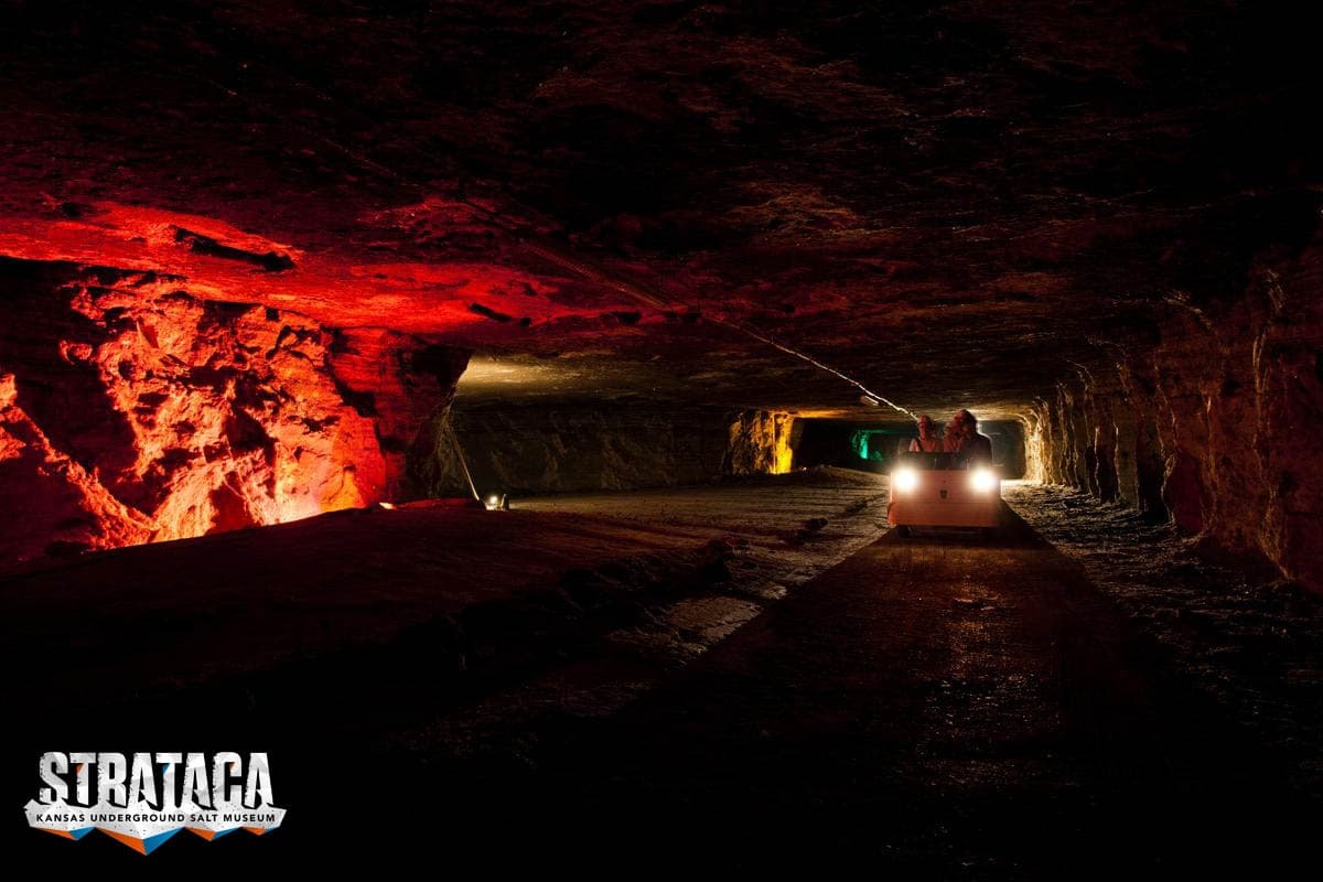 Illuminated underground salt mine tunnel with tour vehicle
