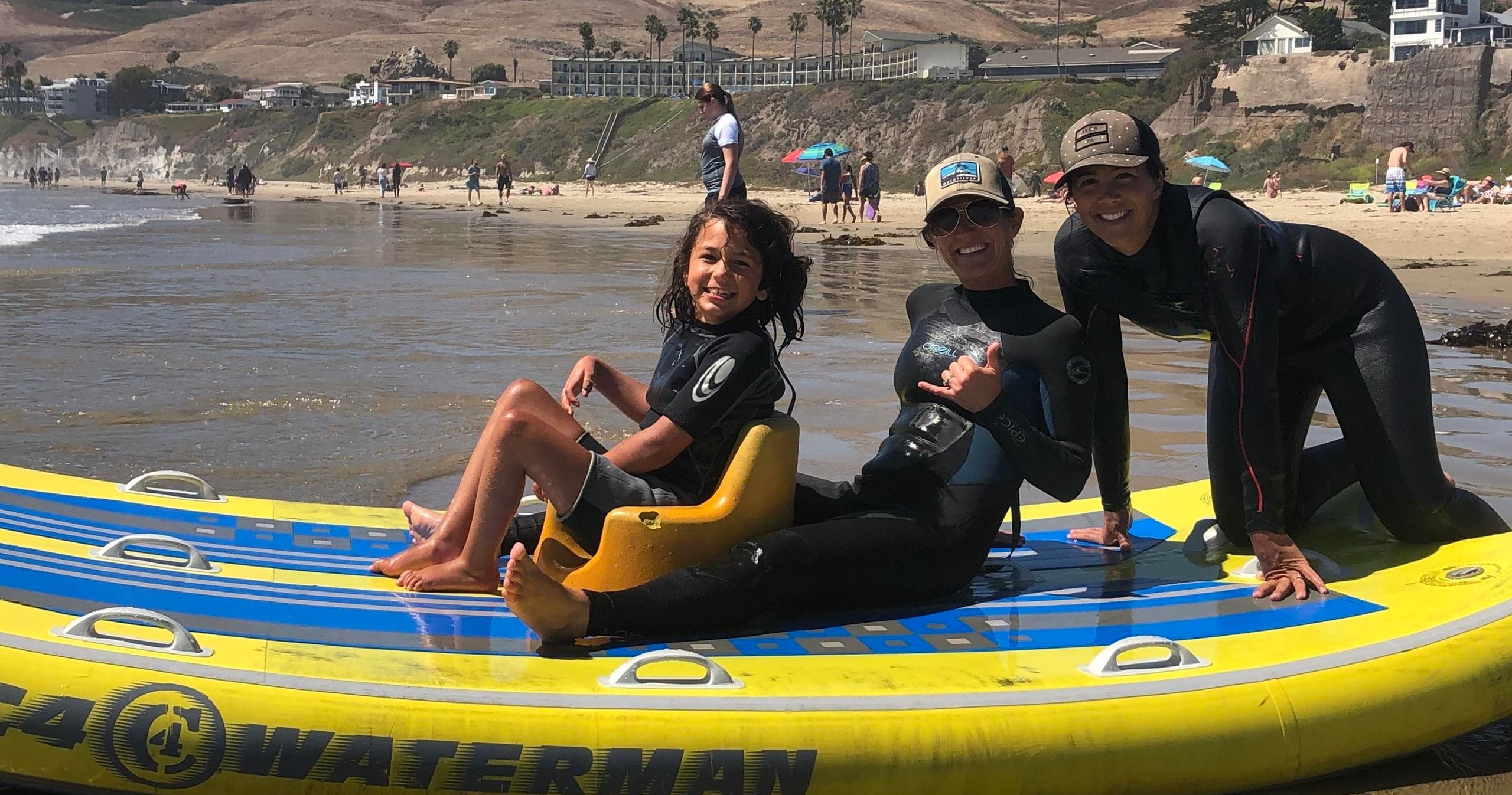 Happy group relaxing on inflatable paddleboard at beach