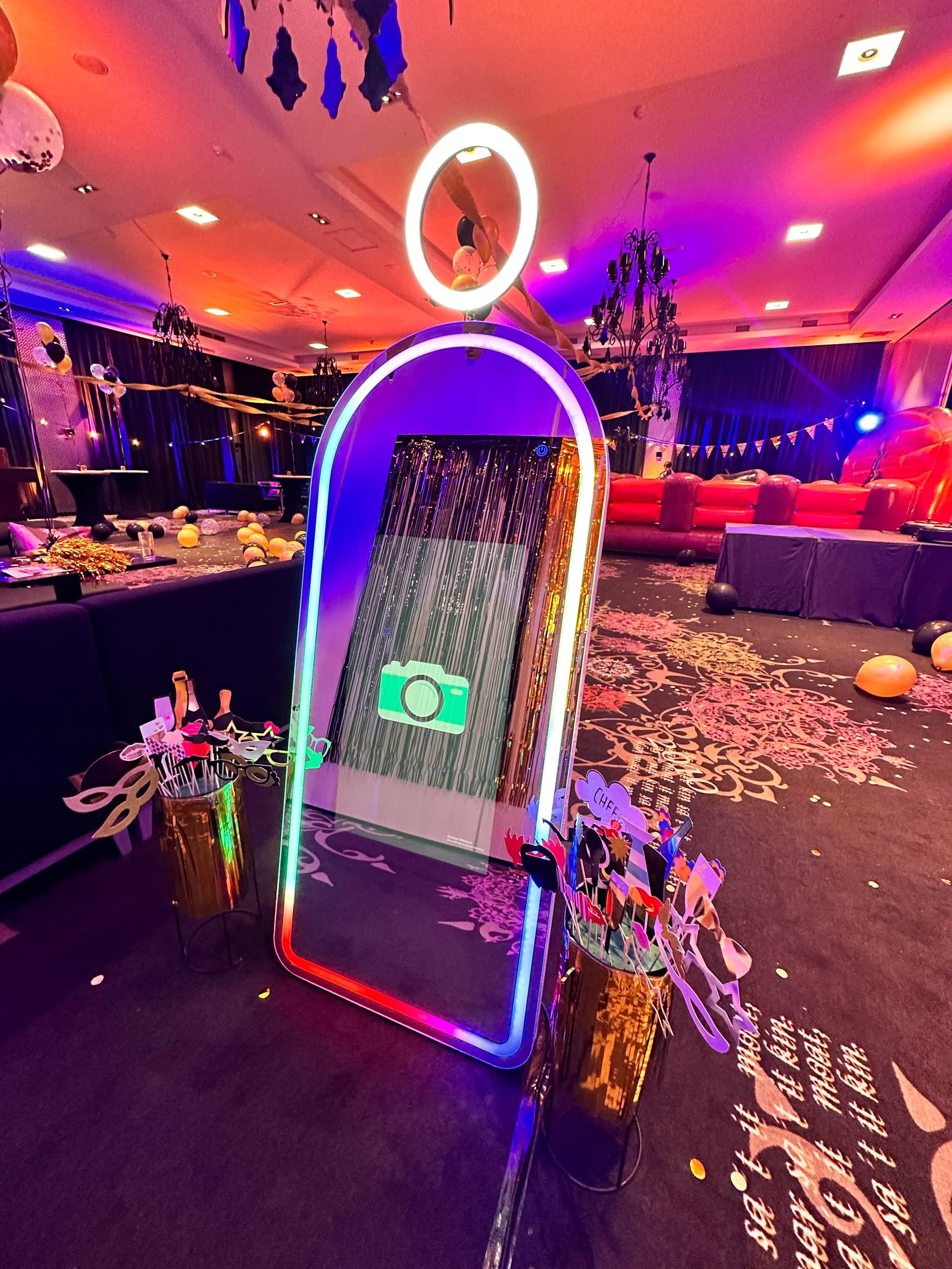 Interactive mirror photo booth with neon arch at indoor party venue