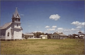 Rural historic church by open field under blue sky, scenic countryside stop