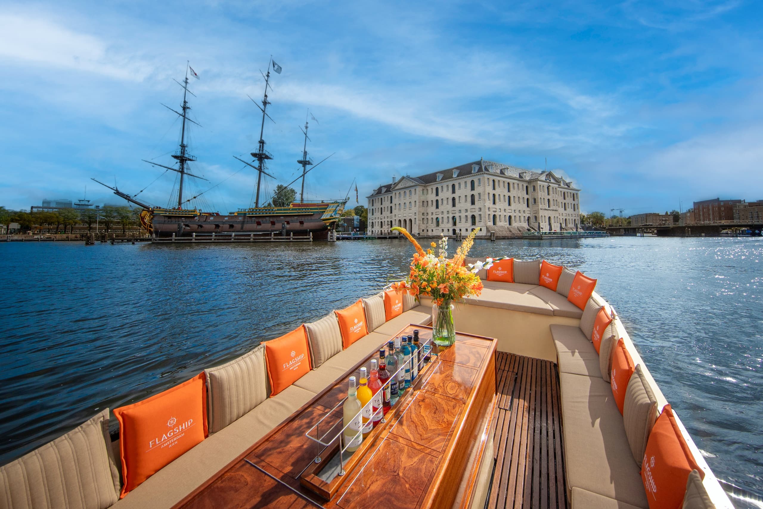 Spacious canal boat deck heading toward historic sailing ship