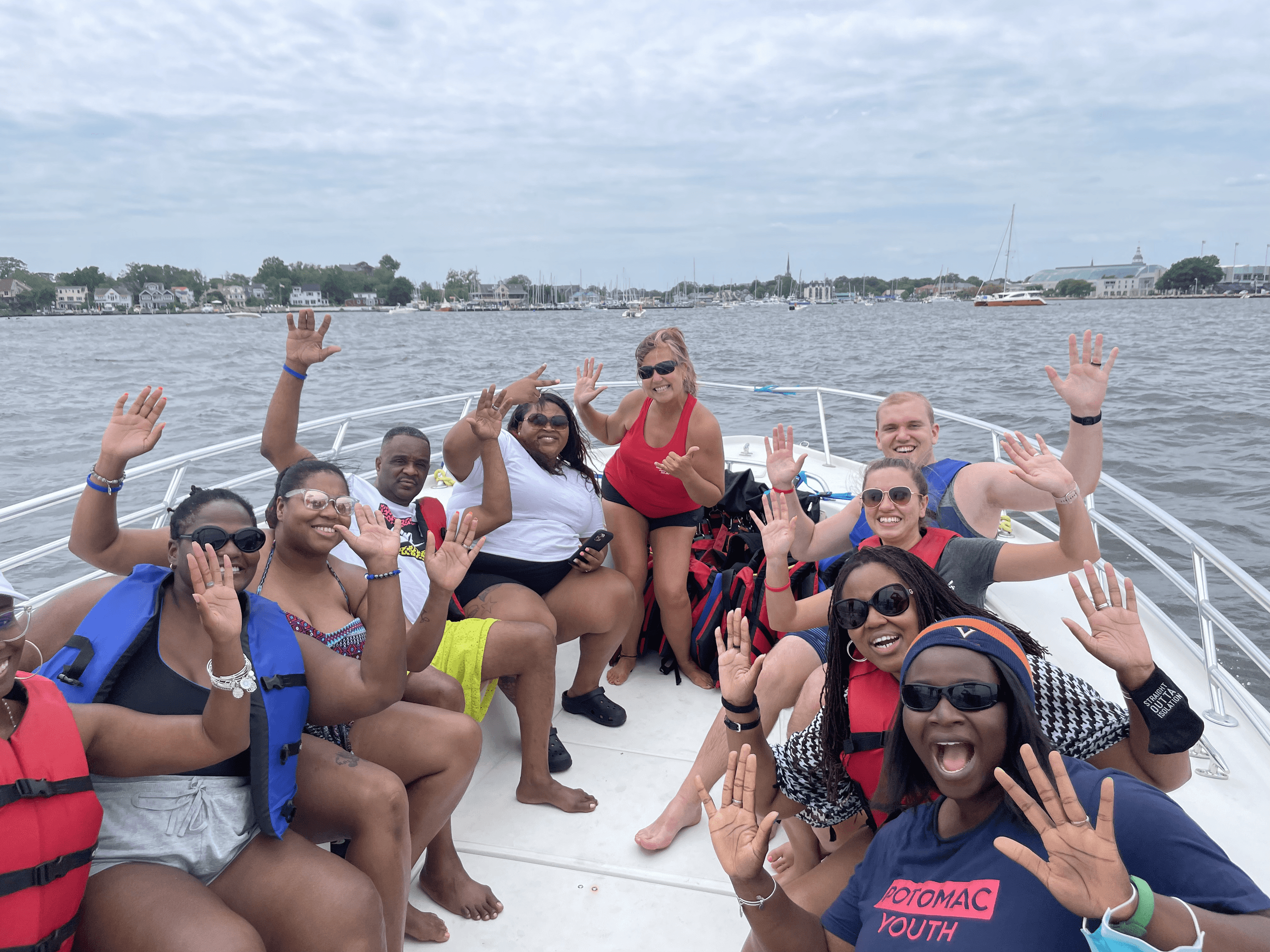 Group on a boat waving before Annapolis parasailing trip on harbor