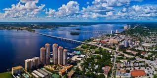 Aerial waterfront city skyline with bridge and blue skies