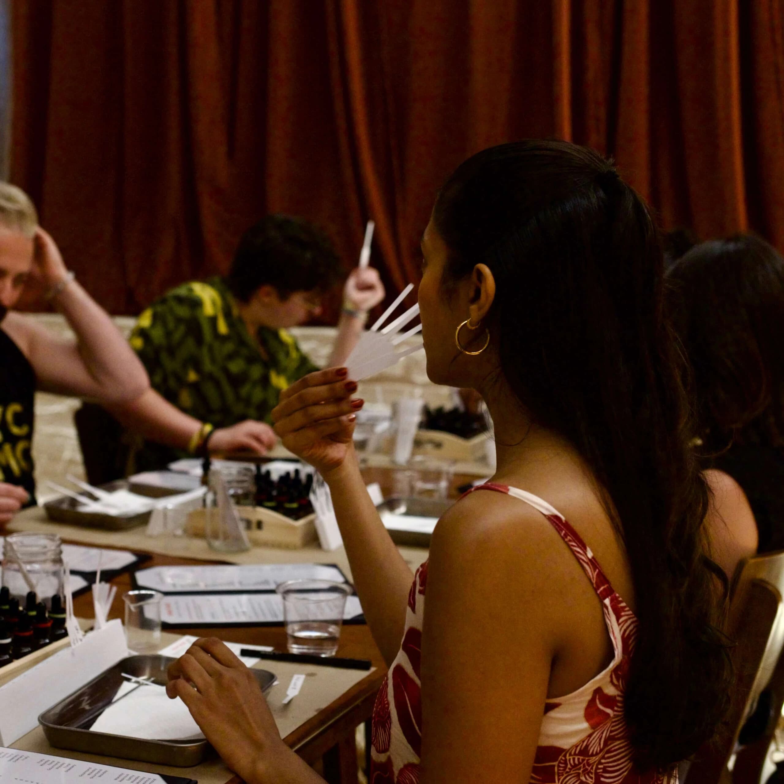 Group perfume workshop participants sampling scents at tables