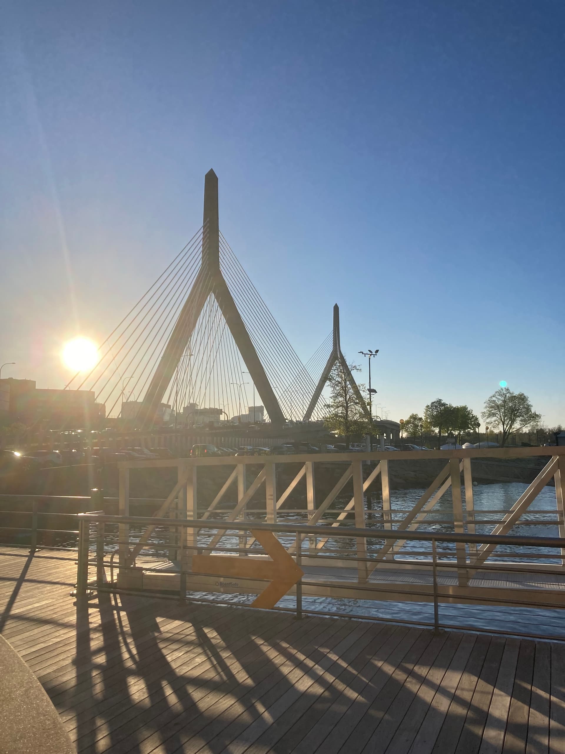 Sunrise over bridge and waterfront promenade with sailing access