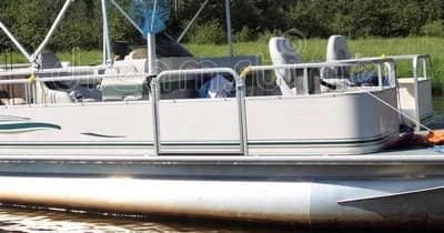 Pontoon boat moored on calm river shore, leisure lake cruising