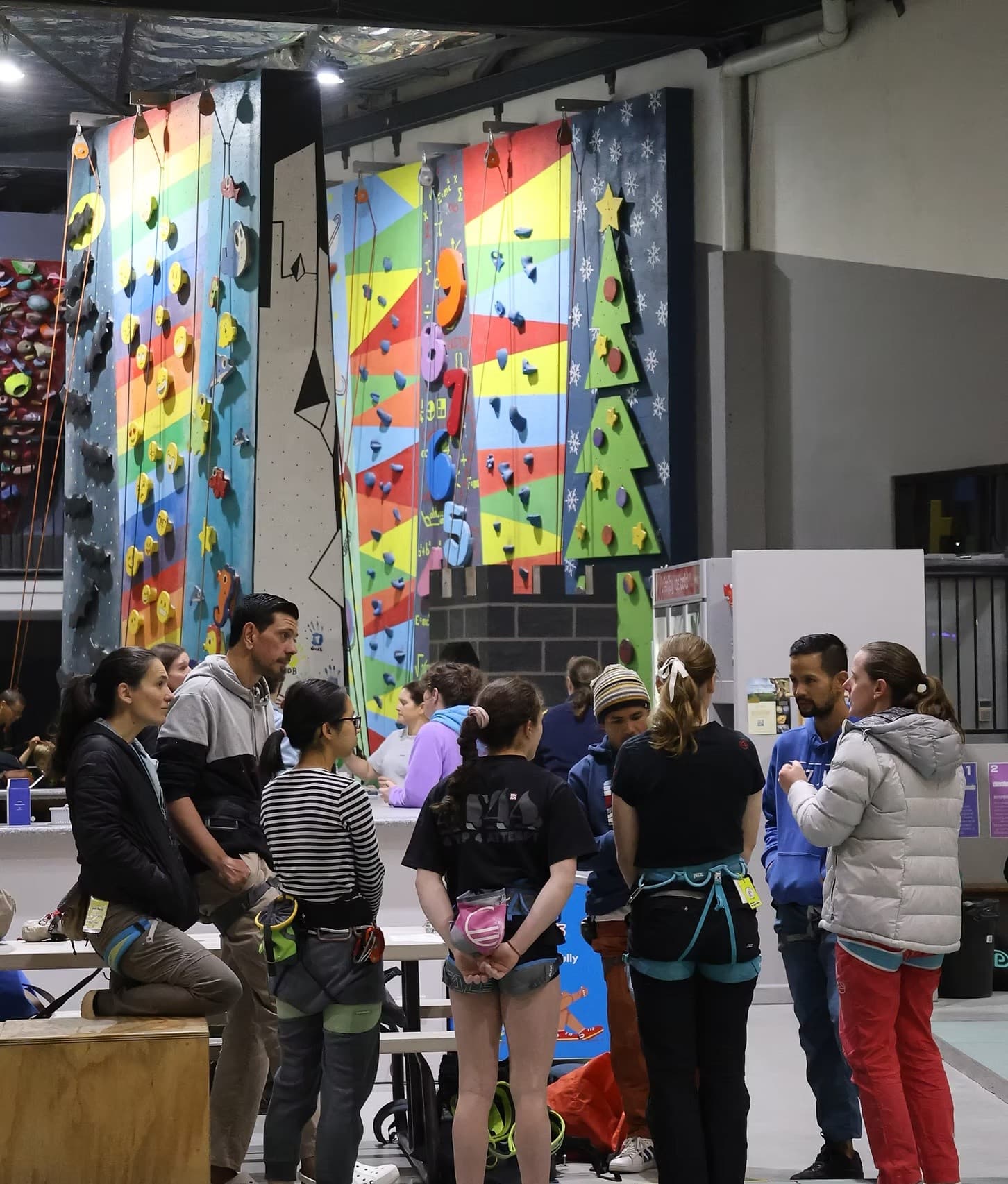 Climbers and instructors briefing by indoor colorful climbing walls