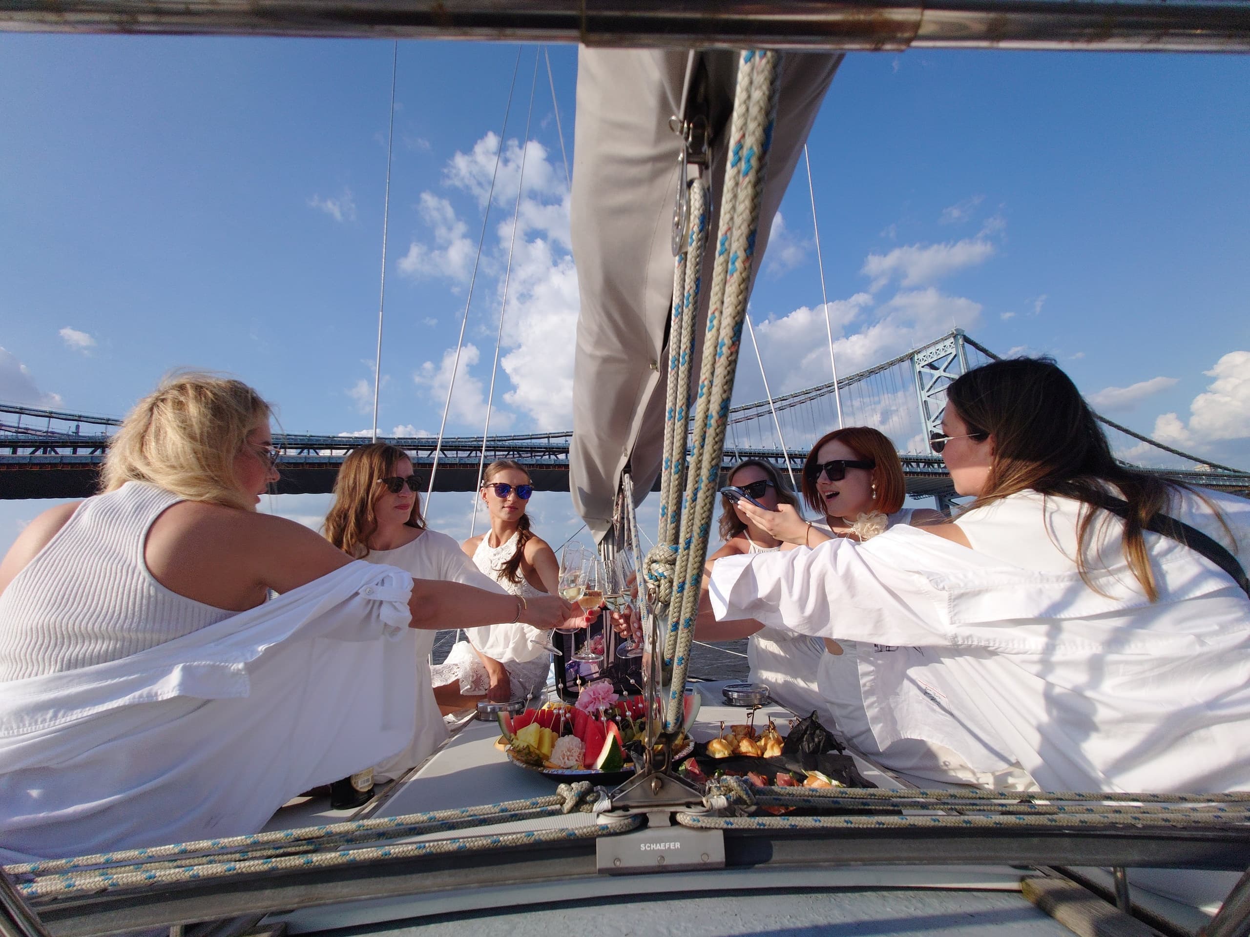 Friends enjoying sailboat gathering and snack spread on deck