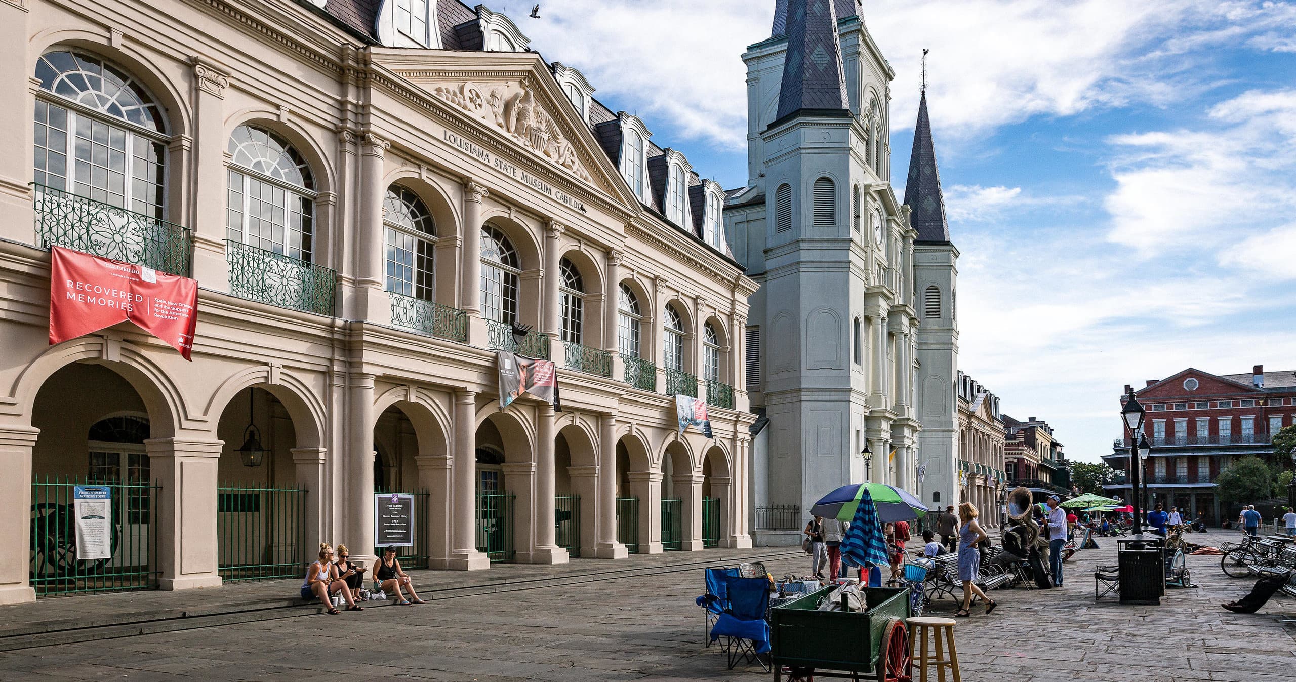 Visitors strolling historic French Quarter plaza by St. Louis Cathedral