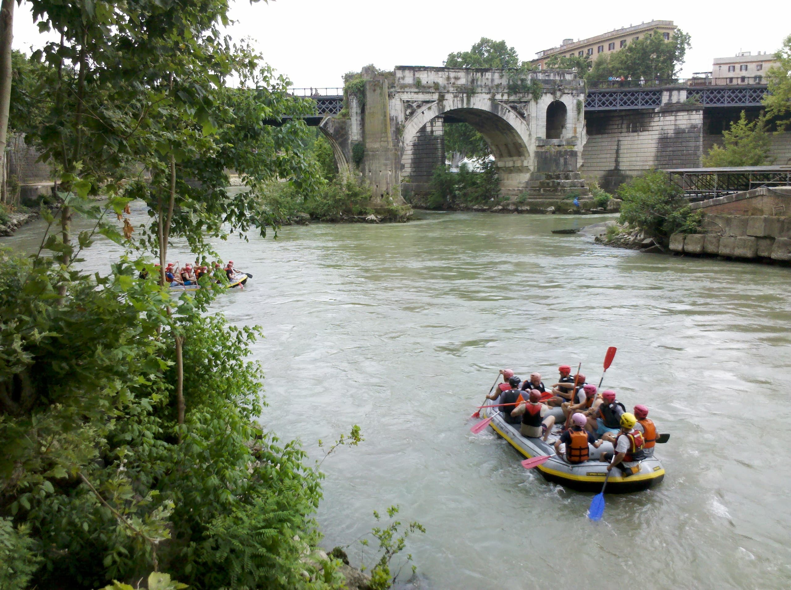 Small rafting team approaching historic bridge on the Tiber River