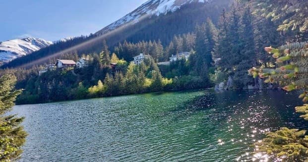 Scenic alpine lake with forested shore and mountain backdrop