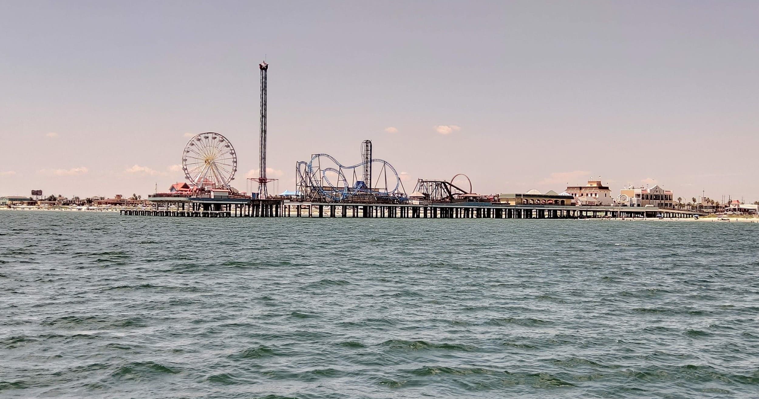 Coastal pier and beachfront amusement park seen from offshore