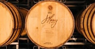 Branded oak barrel head with distillery logo in cellar