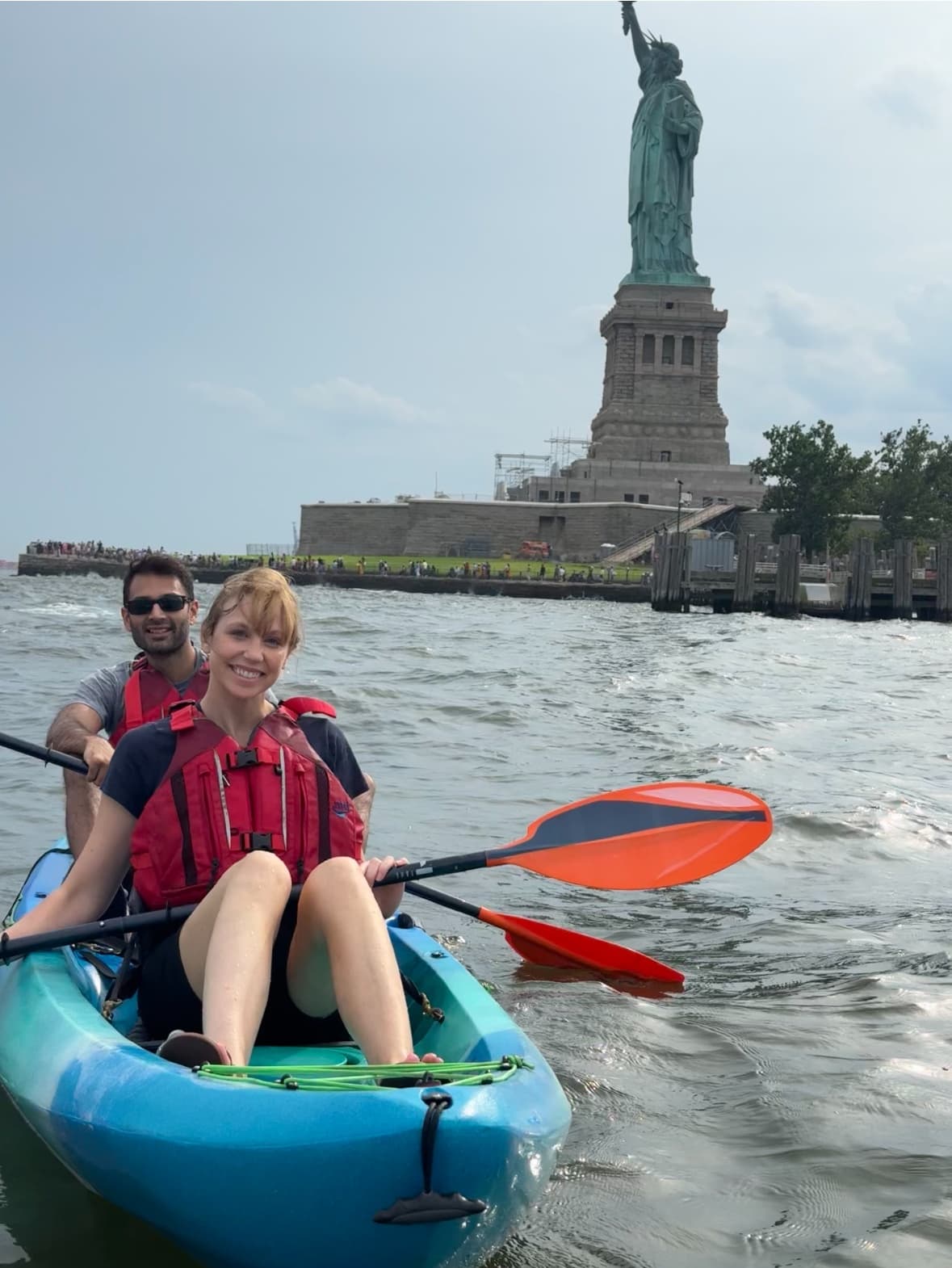 Couple kayaking toward Statue of Liberty in New York Harbor