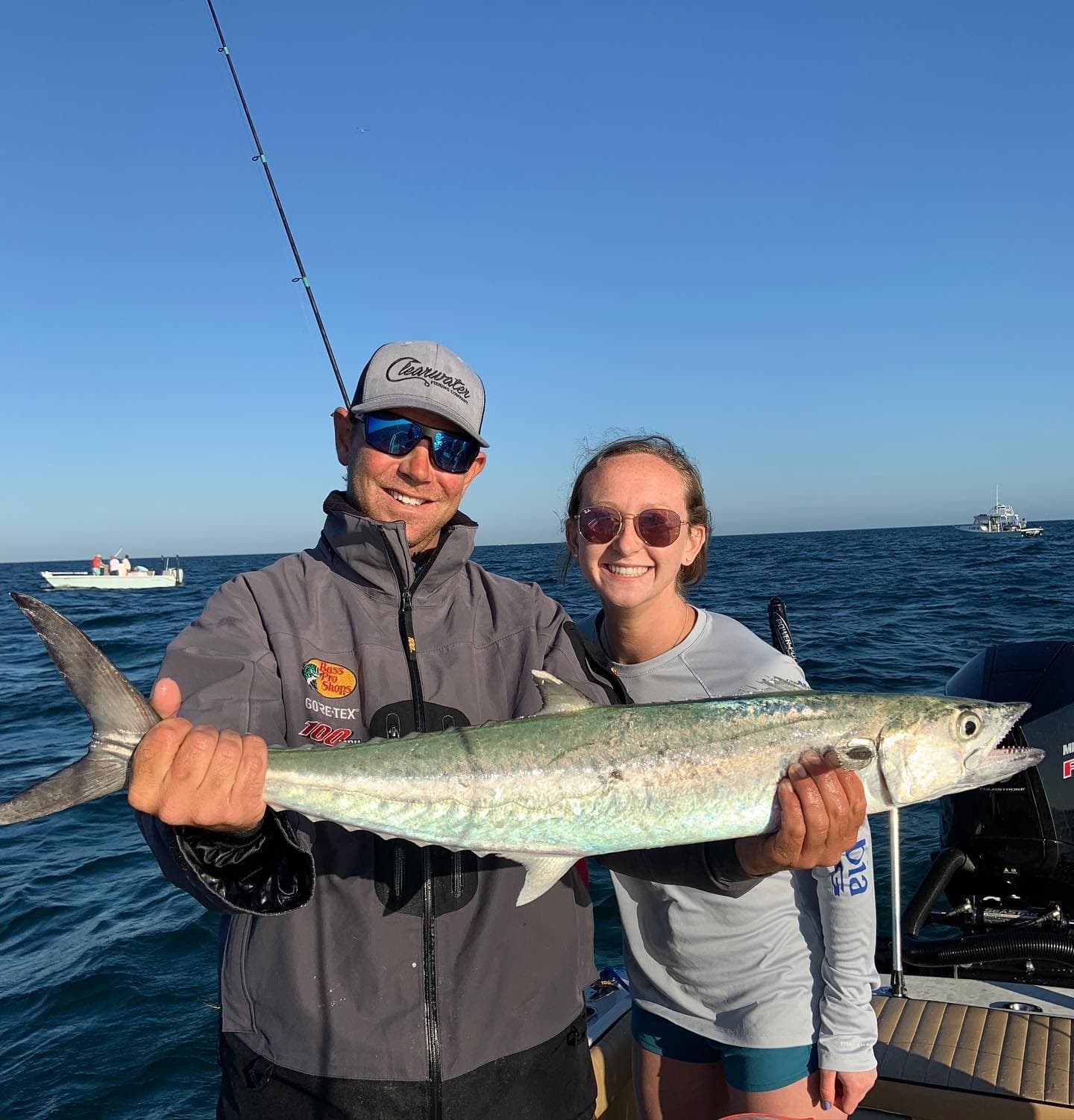 Two anglers smiling with freshly caught kingfish on offshore boat