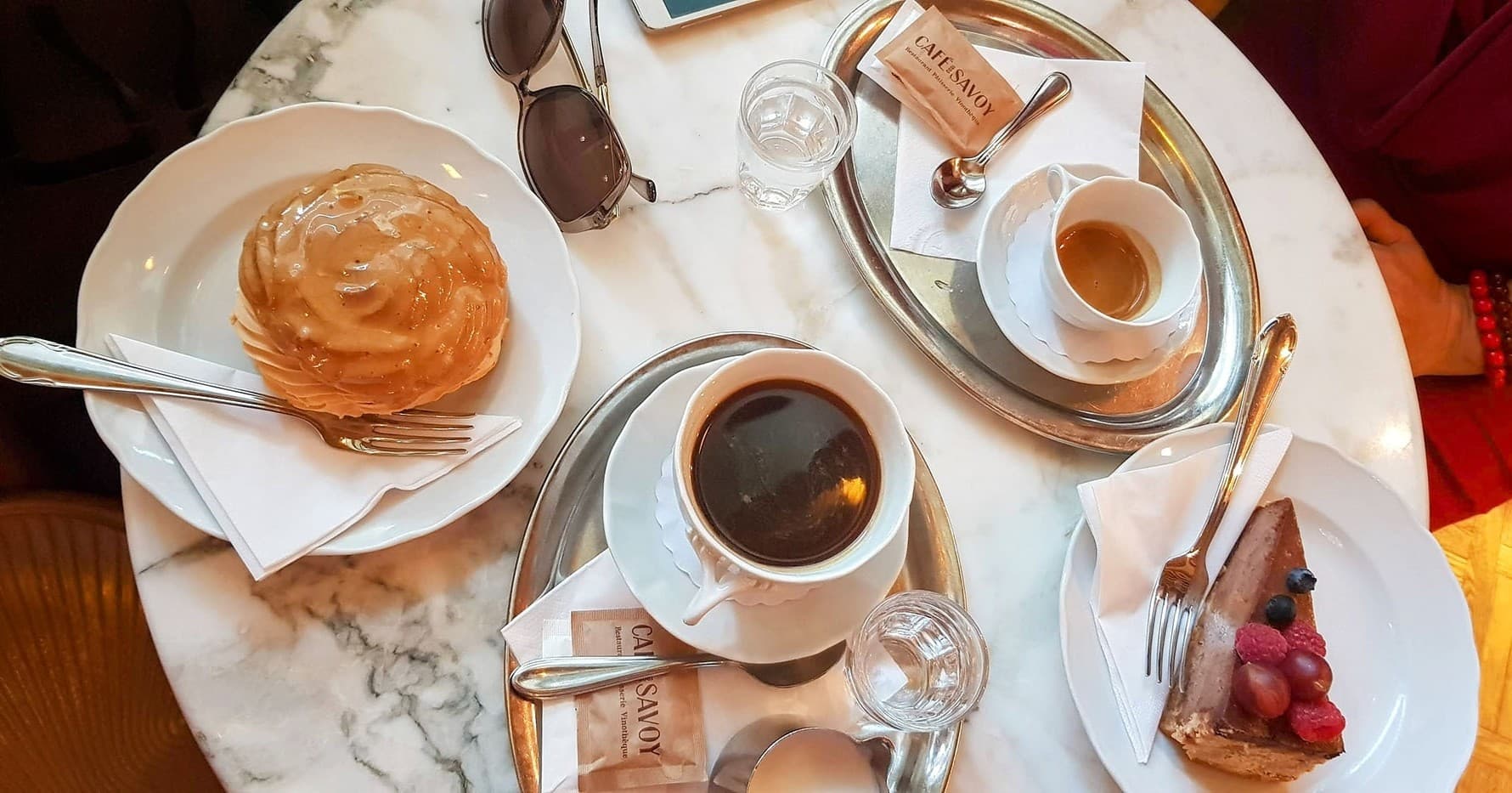 Guests enjoying coffee and pastries inside a Prague cafe