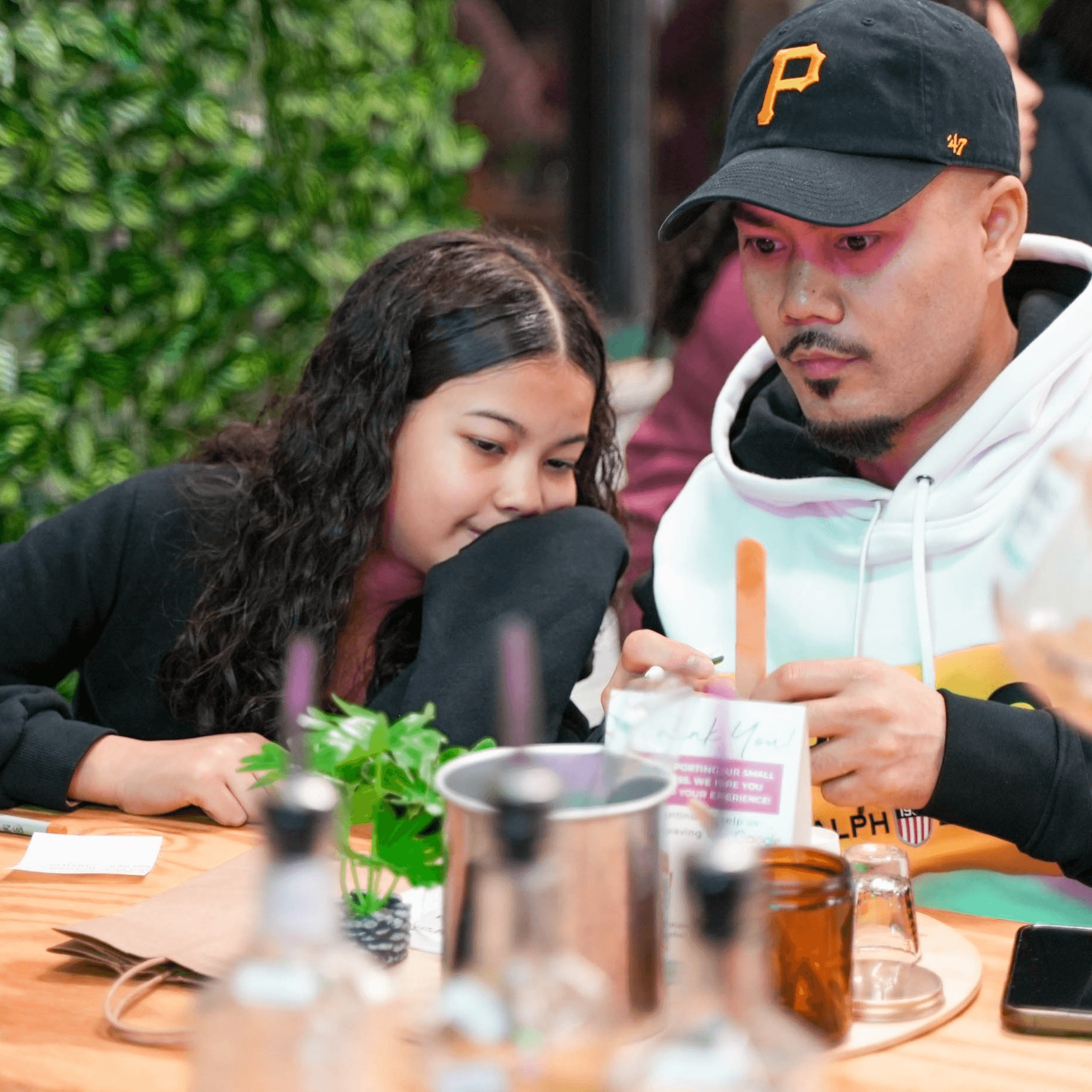 Father and daughter crafting candles together at indoor workshop