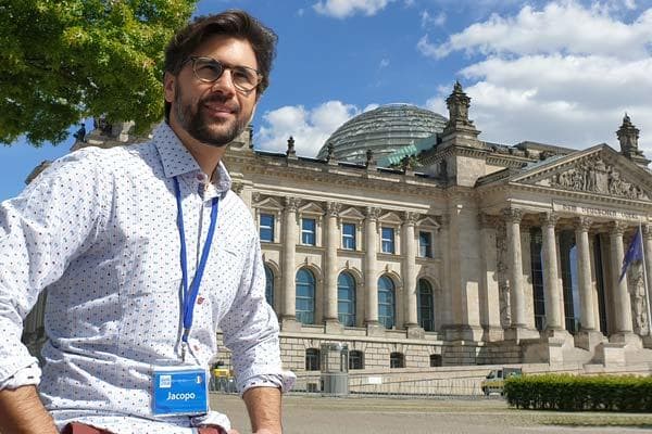 Tour guide posing by historic parliamentary building and dome