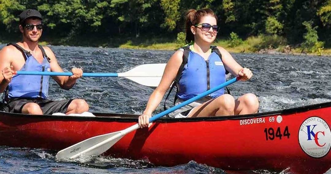 Kayakers canoeing rapids on Alaskan river for wilderness adventure