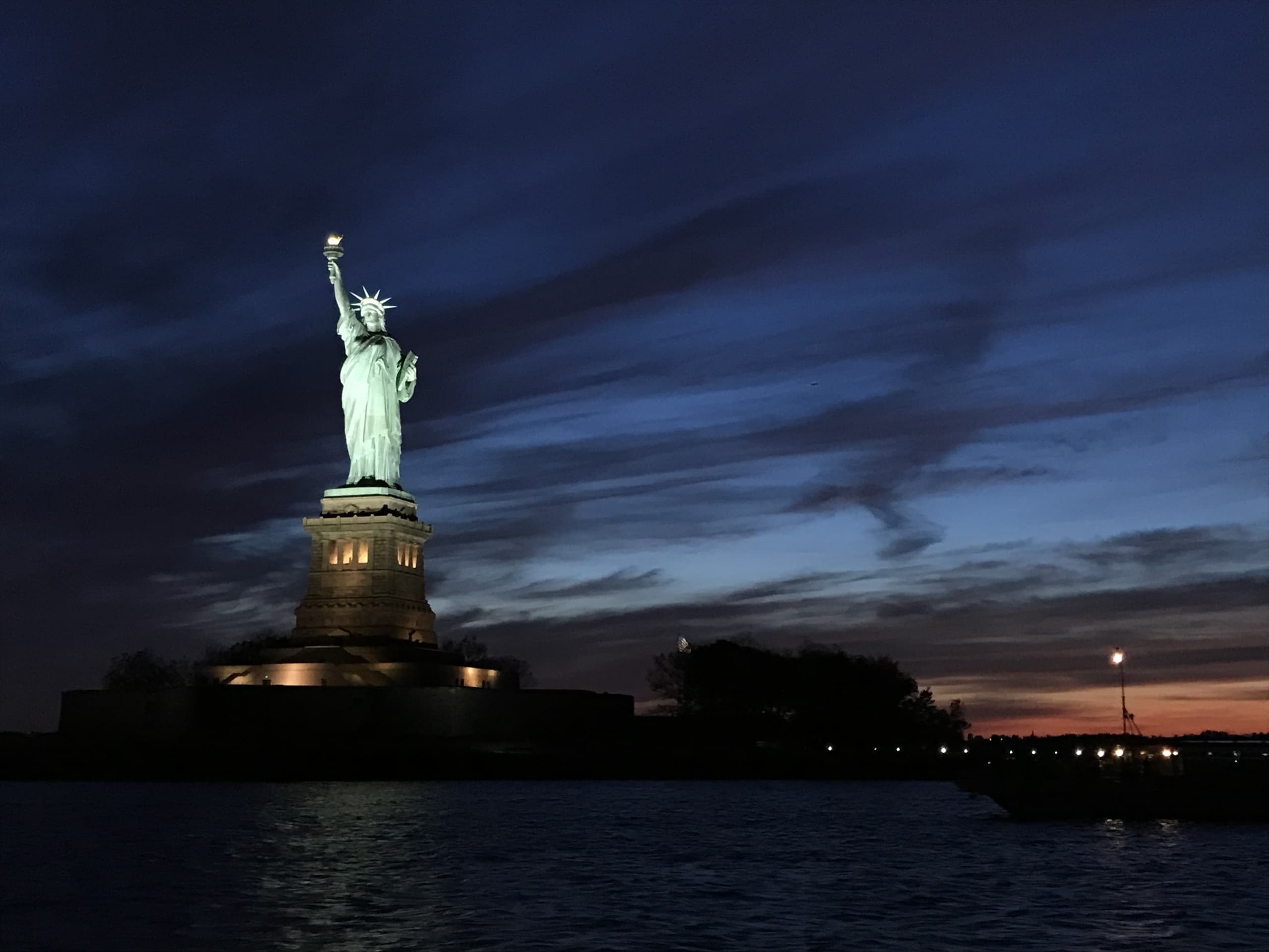 Statue of Liberty at dusk illuminated on Liberty Island, view