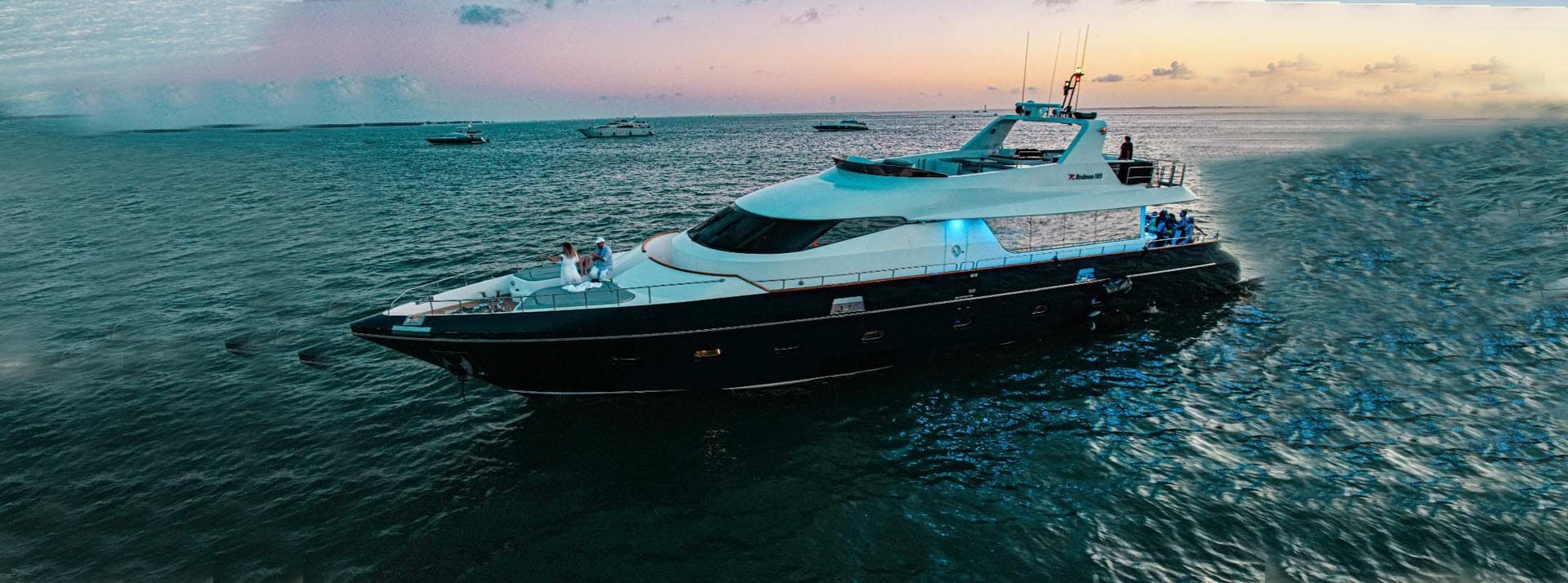 Sleek yacht at sunset on open sea with dramatic sky skyline