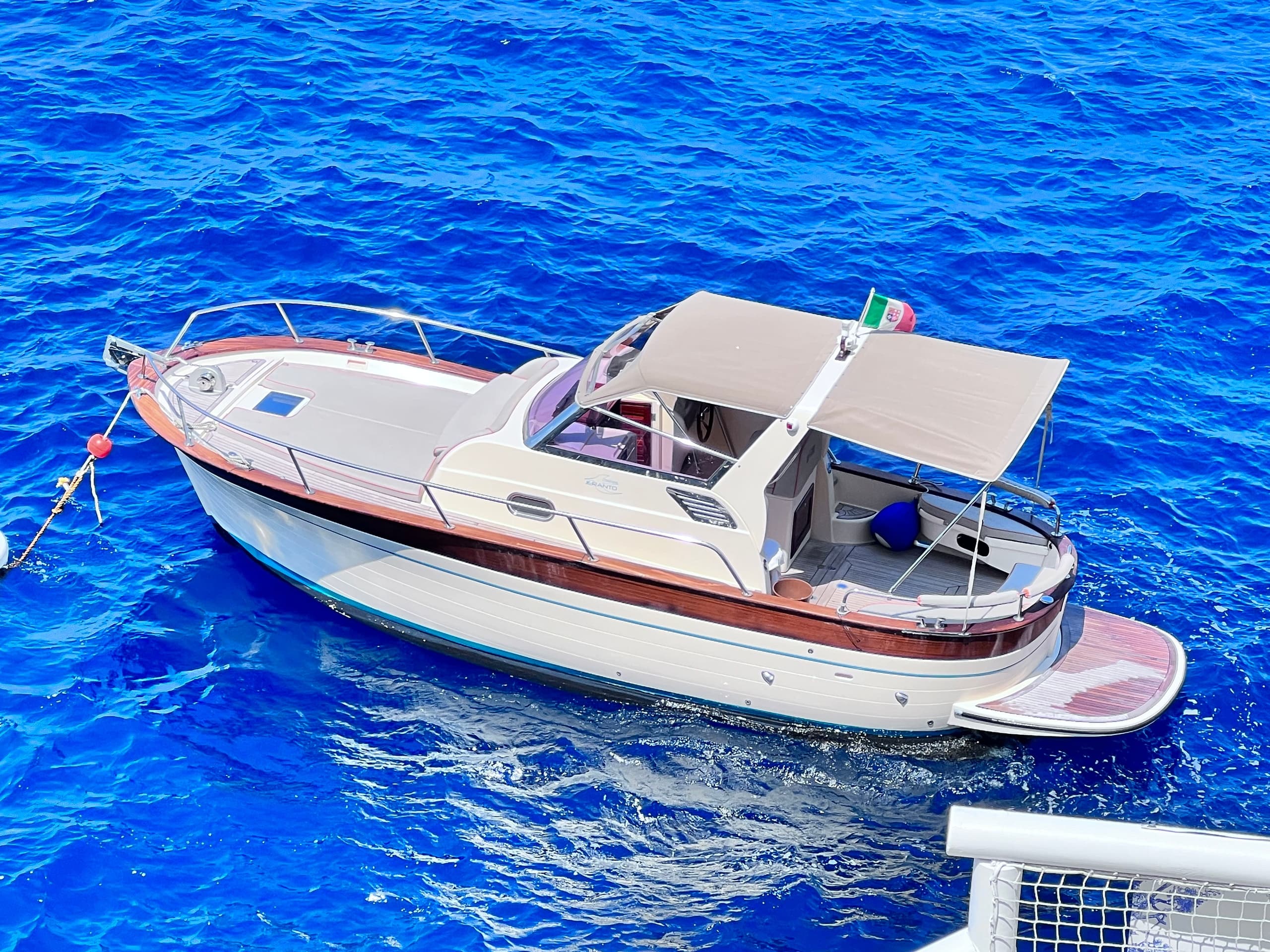 Yacht cutting through vivid blue Mediterranean waters off coast