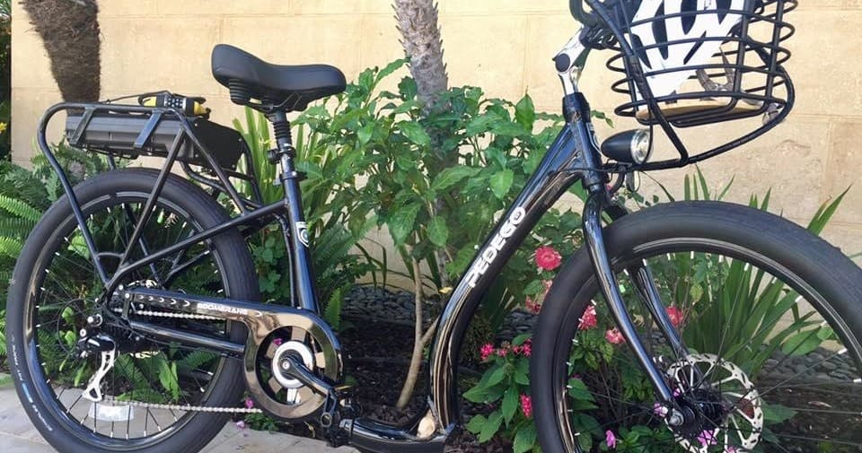 Electric bike parked in tropical garden near resort walkway