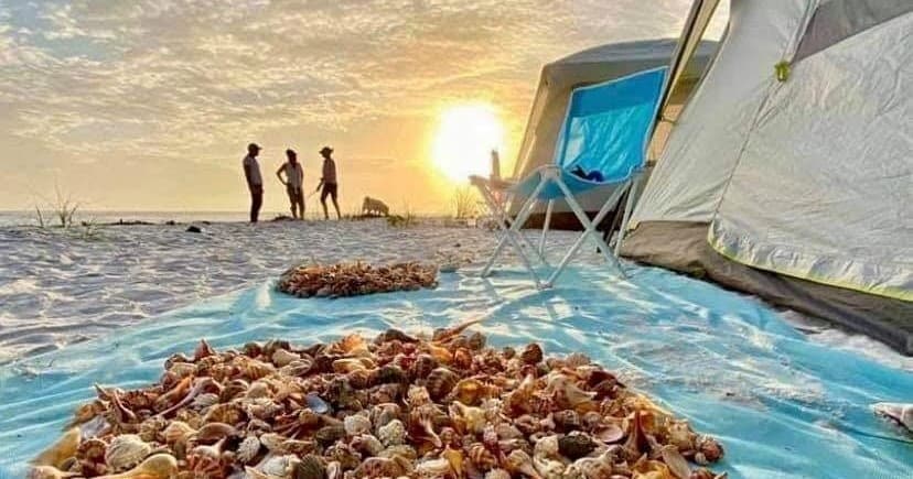 Beach camping at sunset with shell collecting on Florida shore